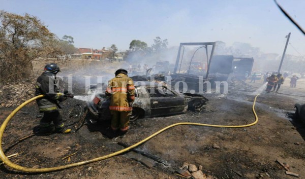 Elementos del Cuerpo de Bomberos mientras sofocan las llamas que destruyeron varios vehículos. Foto: Estalin Irías/ EL HERALDO