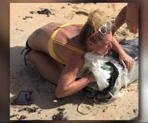 La mujer tiene varios tatuajes en su mano, espalda y hombros.