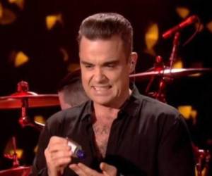 Robbie Williams se desinfectó las manos tras tocar a sus fans en un concierto.