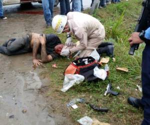 Bomberos brindan atención a uno de los heridos durante asalto dentro de bus que se conducía a la altura de Pimienta, Cortés.