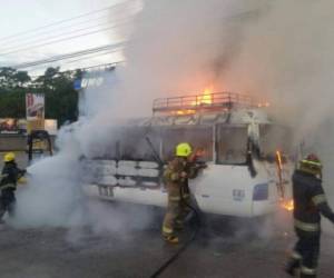 Bomberos mientras intentaban apagar las llamas del vehículo incendiado por criminales.