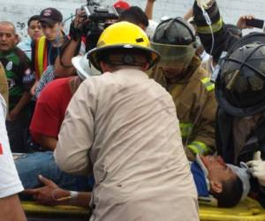Elementos del Cuerpo de Bomberos mientras traslada a uno de los heridos en accidente de tránsito en Choloma, San Pedro Sula.