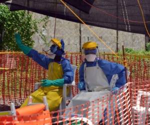 Health workers sit at NGO's Medecins Sans Frontieres (MSF, Doctors Without Borders) Ebola treatment center inside the Samuel K. Doe stadium in Monrovia on October 15, 2014. Dozens of Ebola survivors, now immune to the deadly disease, will meet in Sierra Leone this week to see how they can help tackle the epidemic, the UN said on October 14. AFP PHOTO / ZOOM DOSSO