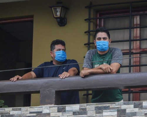 Norman Cardoze, a la izquierda, y su hijo Norman Cardoze Jr. posan para una foto desde el balcón de su casa donde están en cuarentena después de contraer el nuevo coronavirus en Managua, Nicaragua. Foto: AP