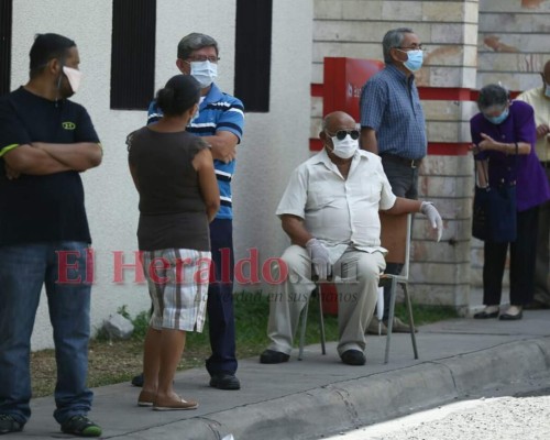 FOTOS: Bajo inclemente sol, hondureños hacen largas filas en bancos  