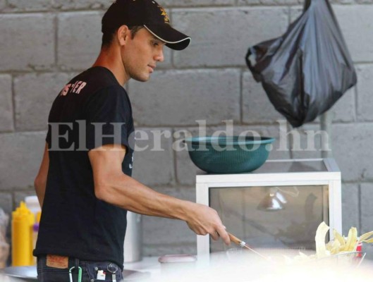 Cristopher Anariba, jugador del Honduras de El progreso, vende sus asados mientras su equipo prepara la final