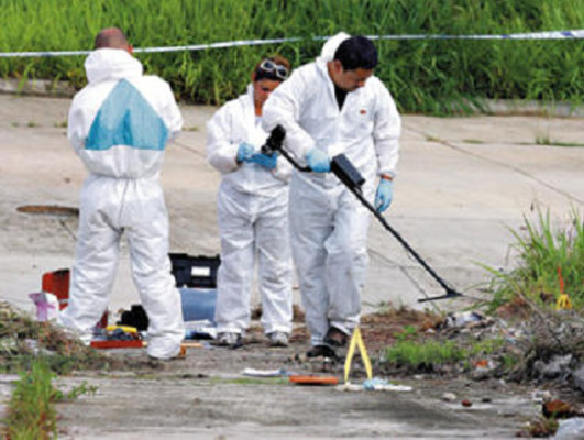 Agentes buscan evidencias en la escena del crimen
