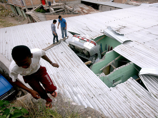 Mujer y su nieto se salvan de morir al caer con su carro sobre casa