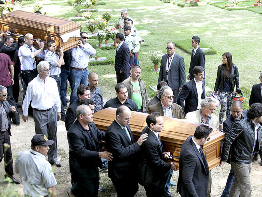 Relatives and friends carry the remains of Monica Spear, right, and of her ex-husband Thomas Henry Berry, top left, during their funeral at the East Cemetery in Caracas, Venezuela, Friday, Jan. 10, 2014. Robbers killed actress Spear, 29, and her former husband Berry, 39, late Monday night on an isolated stretch of highway while the couple was returning to the capital by car with their 5-year-old daughter from a vacation. (AP Photo/Alejandro Cegarra)