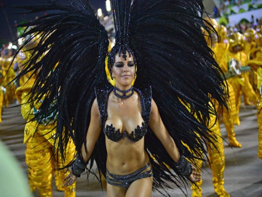 A reveler of the Mocidade samba school performs during the second night of carnival parade at the Sambadrome in Rio de Janeiro on March 3, 2014. AFP PHOTO / CHRISTOPHE SIMON