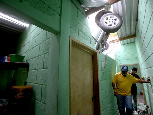 Mujer y su nieto se salvan de morir al caer con su carro sobre casa