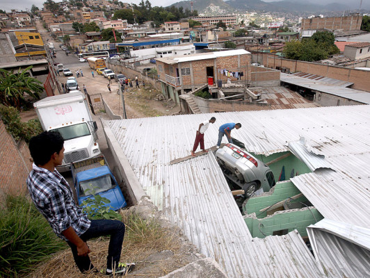 Mujer y su nieto se salvan de morir al caer con su carro sobre casa