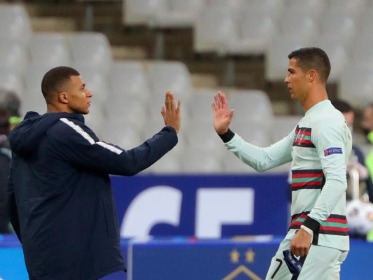 En esta foto del domingo 11 de octubre de 2020, el francés Kylian Mbappé y el portugués Cristiano Ronaldo se saludan previo a un partido amistoso en el Stade de France en Saint-Denis, norte de París.