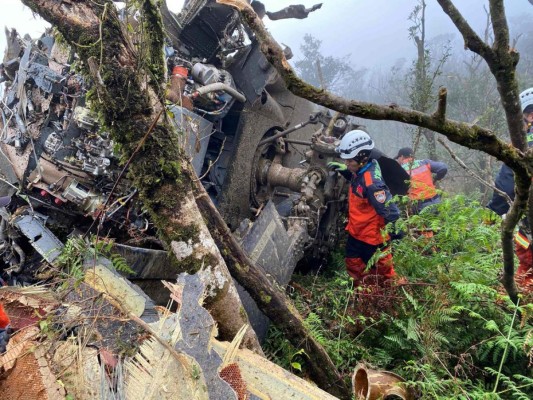 Los rescatistas buscando sobrevivientes después de que un helicóptero militar Black Hawk se estrelló contra las montañas. Foto AFP