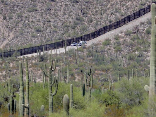 Agentes de la Oficina de Aduanas y Protección Fronteriza recorren una sección del muro fronterizo internacional que atraviesa el Monumento Nacional Organ Pipe, en Lukeville, Arizona. Foto AP