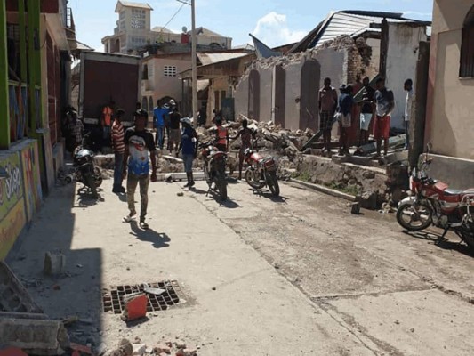 La gente observa las casas destruidas después de un terremoto el 14 de agosto de 2021 en Jeremie, suroeste de Haití. Foto: Agencia AFP.