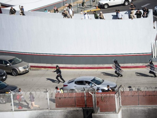 Fotos del momento en el que migrantes de la caravana saltaron valla fronteriza de Estados Unidos, pero fueron detenidos con gases lacrimógenos