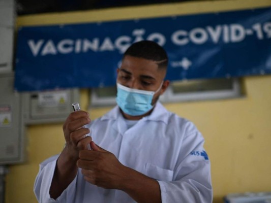 Un profesional de la salud prepara una dosis de la vacuna covid-19 en la estación Recreio de BRT (Bus Rapid Transit) durante el primer día sin uso obligatorio de mascarilla al aire libre en Río de Janeiro, Brasil, el 28 de octubre de 2021. Río de Janeiro es levantando su requisito de máscara covid-19 para áreas al aire libre a partir del jueves, dijo el gobernador del estado, ya que Brasil, una vez azotado por la pandemia, avanza rápidamente con las vacunas. Foto: AFP