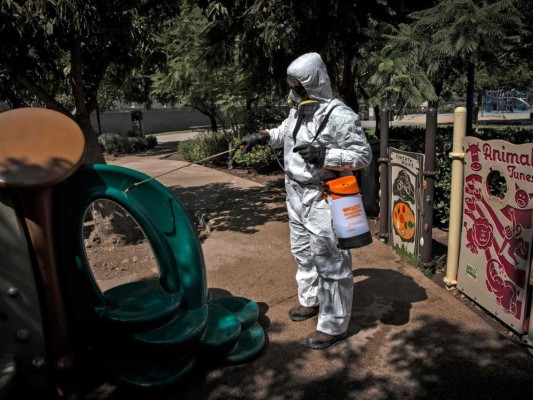 Un trabajador desinfecta los juegos infantiles como medida preventiva contra la propagación del nuevo coronavirus, COVID-19, en el parque Bicentenario, en Santiago. Foto: Agencia AFP.