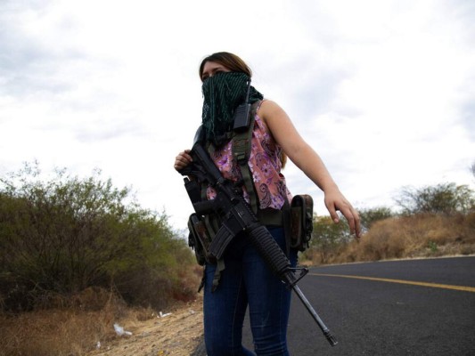 Una mujer armada vigila las afueras de El Terrero, en el estado de Michoacán, México. Foto AP