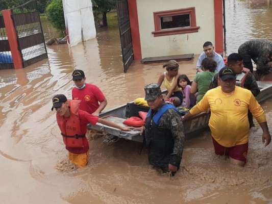 Decenas de personas fueron rescatadas de las inundaciones en el valle de Sula a bordo de un tractor.