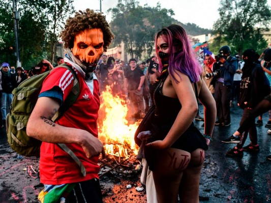 Manifestantes disfrazados participan en una protesta contra las políticas económicas del gobierno en Santiago, el 31 de octubre de 2019, durante las celebraciones de Halloween.