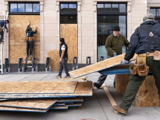 En el centro de Washington, el sonido de martillos y herramientas eléctricas inundaba las calles, mientras trabajadores tapiaban decenas de negocios previendo posibles protestas durante o tras las elecciones en EEUU 2020. Foto: AP.