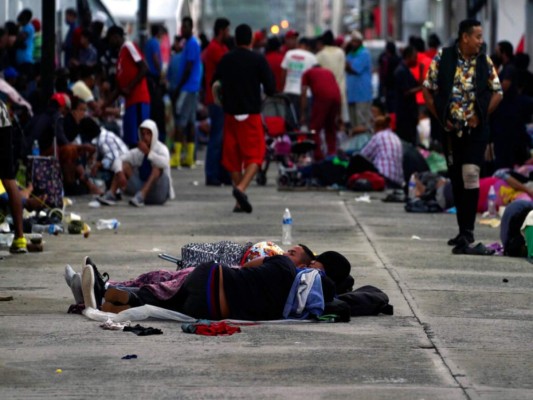 Migrantes, la mayoría procedentes de Centroamérica, duermen en la calle en la localidad de Huixtla, en el estado de Chiapas, México, el martes 26 de octubre de 2021. (AP Foto/Marco Ugarte).