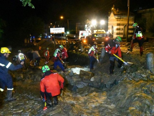 Socorristas quitan en alud de barro de un camino en Codesino, norte de Italia, informaron los bomberos. Foto: AP.