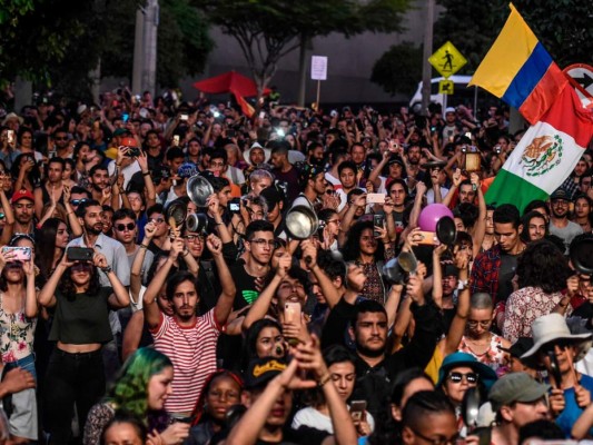 Lla gente golpea sartenes y ollas durante el 'Cacerolazo Latinoamericano' en un concierto en apoyo de la huelga contra el gobierno del presidente colombiano Ivan Duque. AFP.