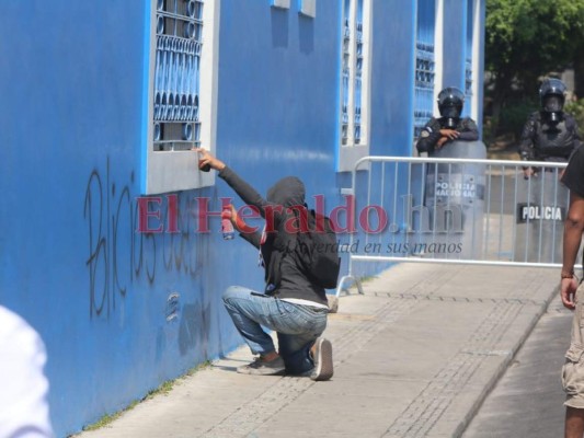 Encapuchados rayan paredes de la sede del Partido Nacional durante marcha del Día del Trabajador
