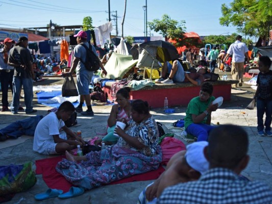 Migrantes hondureños reciben atole y arroz servido en hojas de árbol en Huixtla, México