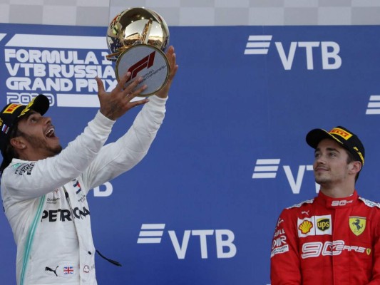 El primer piloto de Mercedes, Lewis Hamilton de Gran Bretaña, celebra en el podio con el tercer piloto de Ferrari, Charles Leclerc de Mónaco, al final del Gran Premio de Rusia de Fórmula 1. Foto: AP.