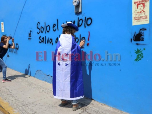 Encapuchados rayan paredes de la sede del Partido Nacional durante marcha del Día del Trabajador