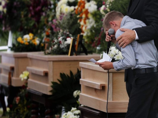 Una madre y sus dos hijos, muertos en la masacre del lunes 4 de noviembre, fueron enterrados en la misma fosa. Uno de los hijos de ella llora al lado del ferétro de su madre mientra da un discurso. Foto: AP