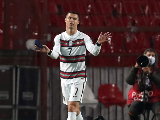 Portugal's Cristiano Ronaldo holding captain's armband, left, reacts during the World Cup 2022 group A qualifying soccer match against Serbia at the Rajko Mitic stadium in Belgrade, Serbia, Saturday, March 27, 2021. The captain’s armband which Cristiano Ronaldo threw to the pitch after his overtime winning goal was disallowed in a World Cup qualifier against Serbia has been put on auction Tuesday March 30, 2021. The armband is being auctioned by a charity group raising money for surgery of a six-month-old boy from Serbia suffering spinal muscular atrophy. (AP Photo/Darko Vojinovic)