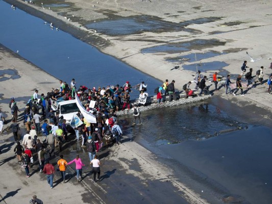 Fotos del momento en el que migrantes de la caravana saltaron valla fronteriza de Estados Unidos, pero fueron detenidos con gases lacrimógenos