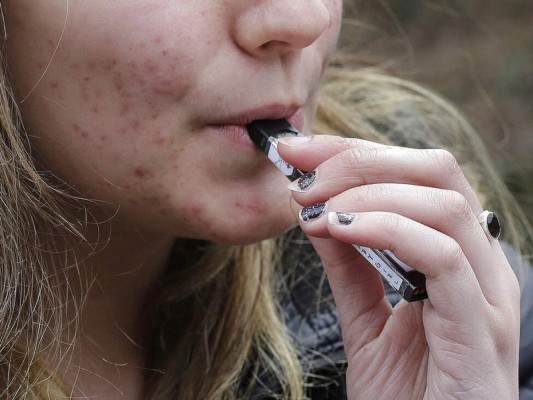 Una estudiante de secundaria vapeando cerca de la escuela en Cambridge, el uso de cigarrillos electrónicos entre los adolescentes alcanza niveles epidémicos. (Foto: AP)