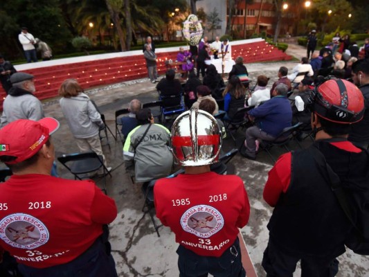Miembros del equipo de rescate especializado 'Los Topos' (The Moles) y otras personas rinden homenaje a las víctimas del devastador terremoto de 1985, en el barrio de Tlatelolco en la Ciudad de México, el 19 de septiembre de 2018.