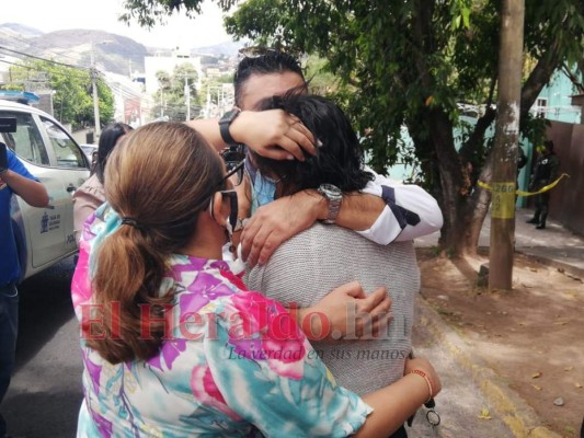Familiares del reconocido abogado se fundieron en un fuerte abrazo al lado de la sangrienta escena del crimen. Foto Estalin Irías| EL HERALDO.