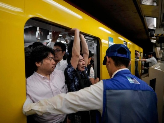 Las autoridades de transporte de Tokio definen sus vagones del metro a 200% de capacidad como con espacio suficiente para que un pasajero lea una revista. Foto: AP.