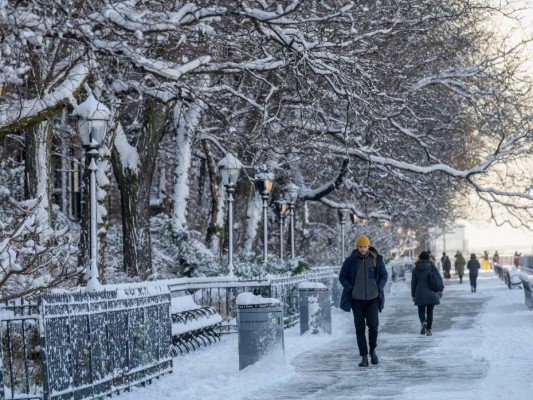 La gente camina por la nieve durante la primera tormenta de nieve de la temporada el 7 de enero de 2022 en la ciudad de Nueva York. Foto: AFP
