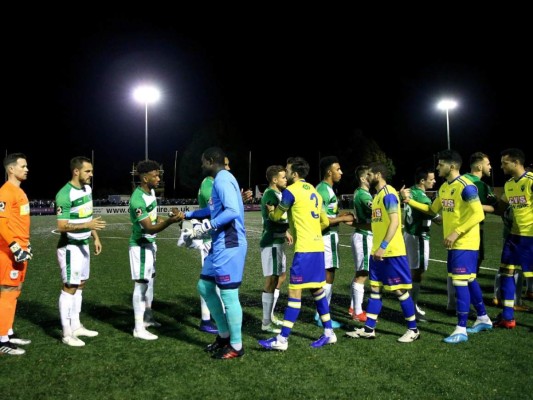 El arquero camerunés Vlery Pajetat y los demás jugadores del Haringey, saludan a sus rivales del Yeovil, antes de un partido eliminatorio para la Copa de la FA, el martes 29 de octubre de 2019. El encuentro original se canceló el 19 de septiembre, por insultos racistas a Pajetat y a otro jugador (Steven Paston/PA via AP)