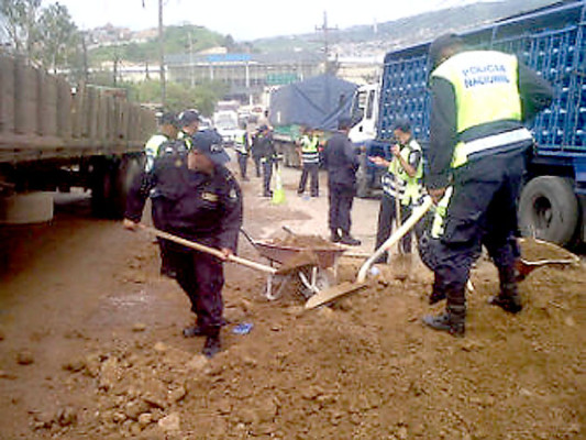 Policías de tránsito tapan baches en la salida a Olancho