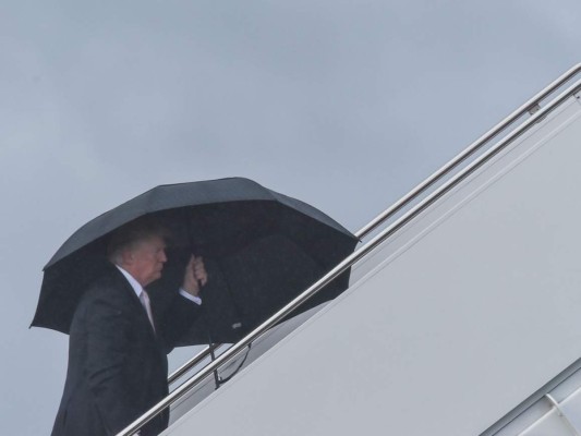 Trump se cubre de la lluvia mientras Melania y su hijo Barron se mojan (FOTOS)