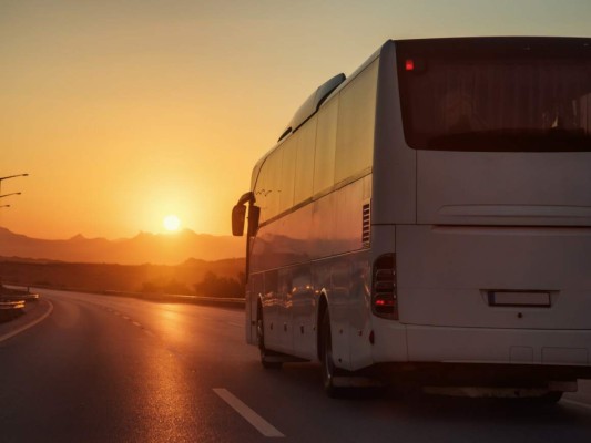 Un migrante iraquí viaja agarrado a los bajos de un autobús