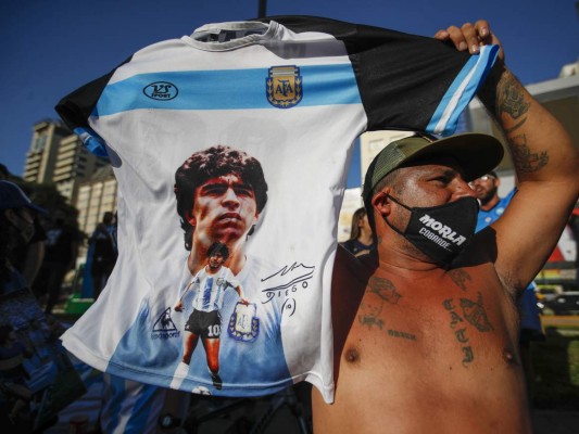 Un individuo alza una camiseta con la imagen del extinto astro del fútbol Diego Maradona durante una marcha para reclamar respuestas por su muerte, en Buenos Aires, el miércoles. Foto:AP