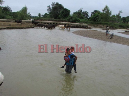 Alumnos del Instituto Unión de Oriente de Jutiapa cruzan un río para asistir a clases