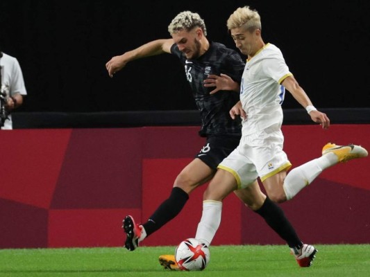 El centrocampista rumano Eduard Florescu (R) dispara y no anota durante el partido de fútbol de primera ronda del grupo B masculino de los Juegos Olímpicos de Tokio 2020 entre Rumania y Nueva Zelanda en el Sapporo Dome en Sapporo. Foto: AFP