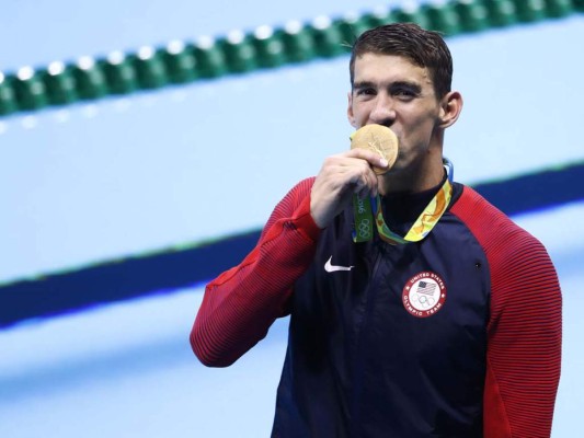 Michael Phelps besa su nueva presea de oro (Foto: AFP)
